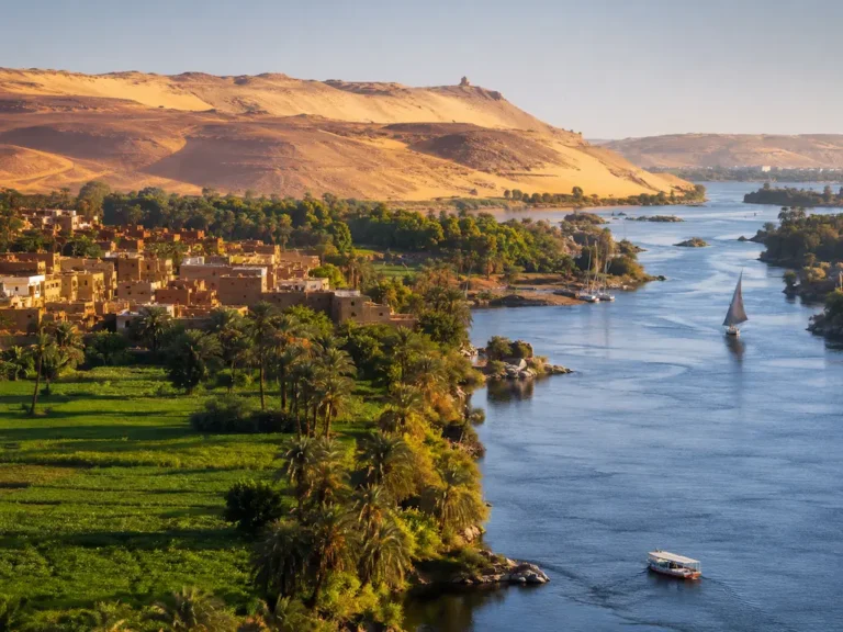 Nile Valley landscape with river, palm trees, farmland, and desert hills in Egypt