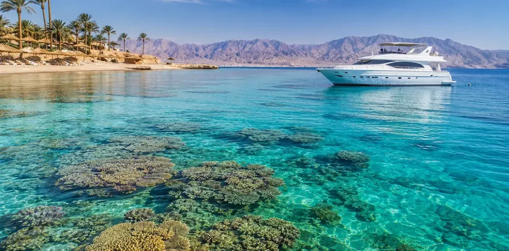 Clear Red Sea water with coral reefs and a luxury yacht in Egypt
