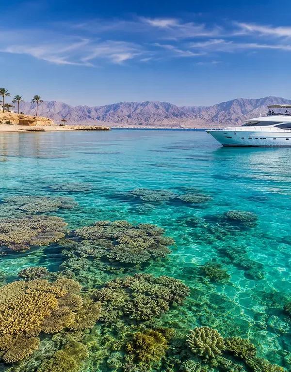Klares Wasser im Roten Meer mit Korallenriffen und einer Luxusyacht in Ägypten
