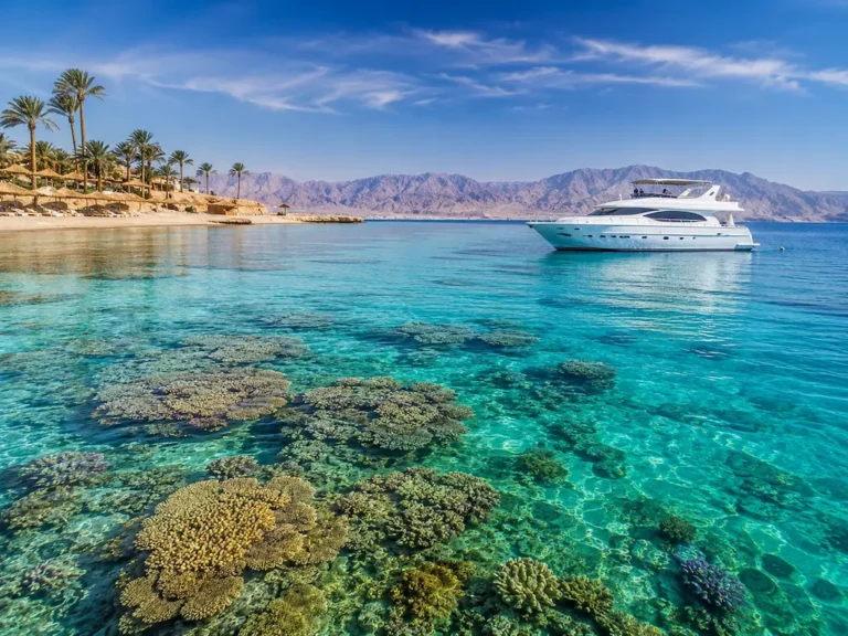 Klares Wasser im Roten Meer mit Korallenriffen und einer Luxusyacht in Ägypten