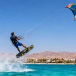Kitesurfer springt über das Rote Meer in Ägypten mit Bergen und Resort im Hintergrund