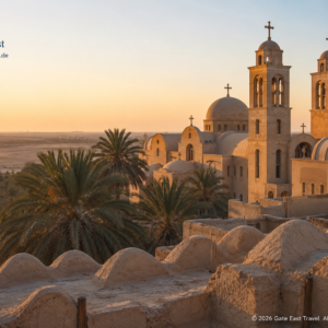 Koptisches Kloster im Wadi El Natrun mit Kirchtürmen, Palmen und Wüstenlandschaft