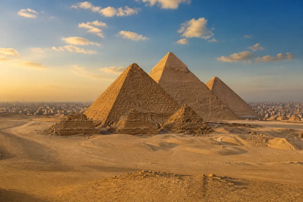 Pyramiden von Gizeh im warmen Sonnenlicht mit Kairo in der Ferne