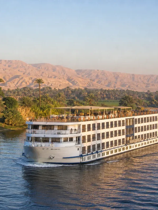 Nilkreuzfahrtschiff vor palmengesäumten Ufern in Oberägypten