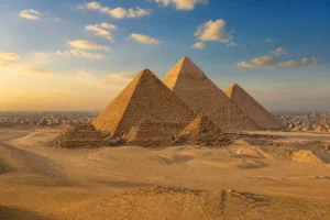 Giza Pyramids illuminated by warm sunlight with Cairo in the distance