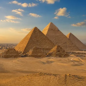 Giza Pyramids illuminated by warm sunlight with Cairo in the distance